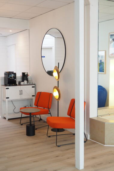 Coin d'attente aménagé avec deux fauteuils et une table basse au studio Duchess Production à Caen